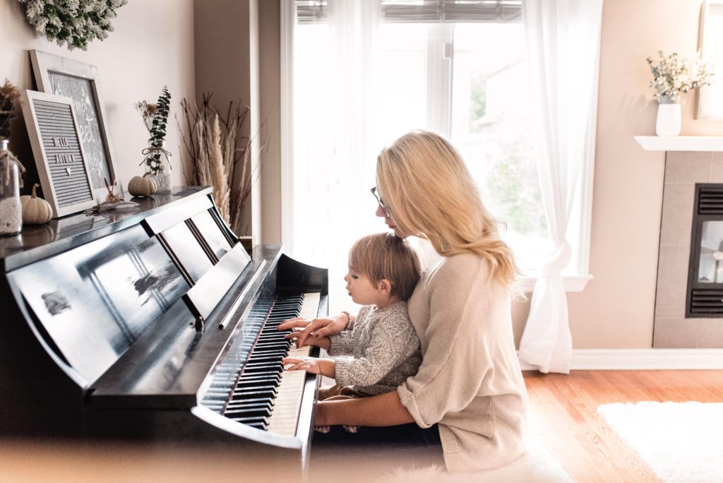 A Mother playing the piano with her child on her lap